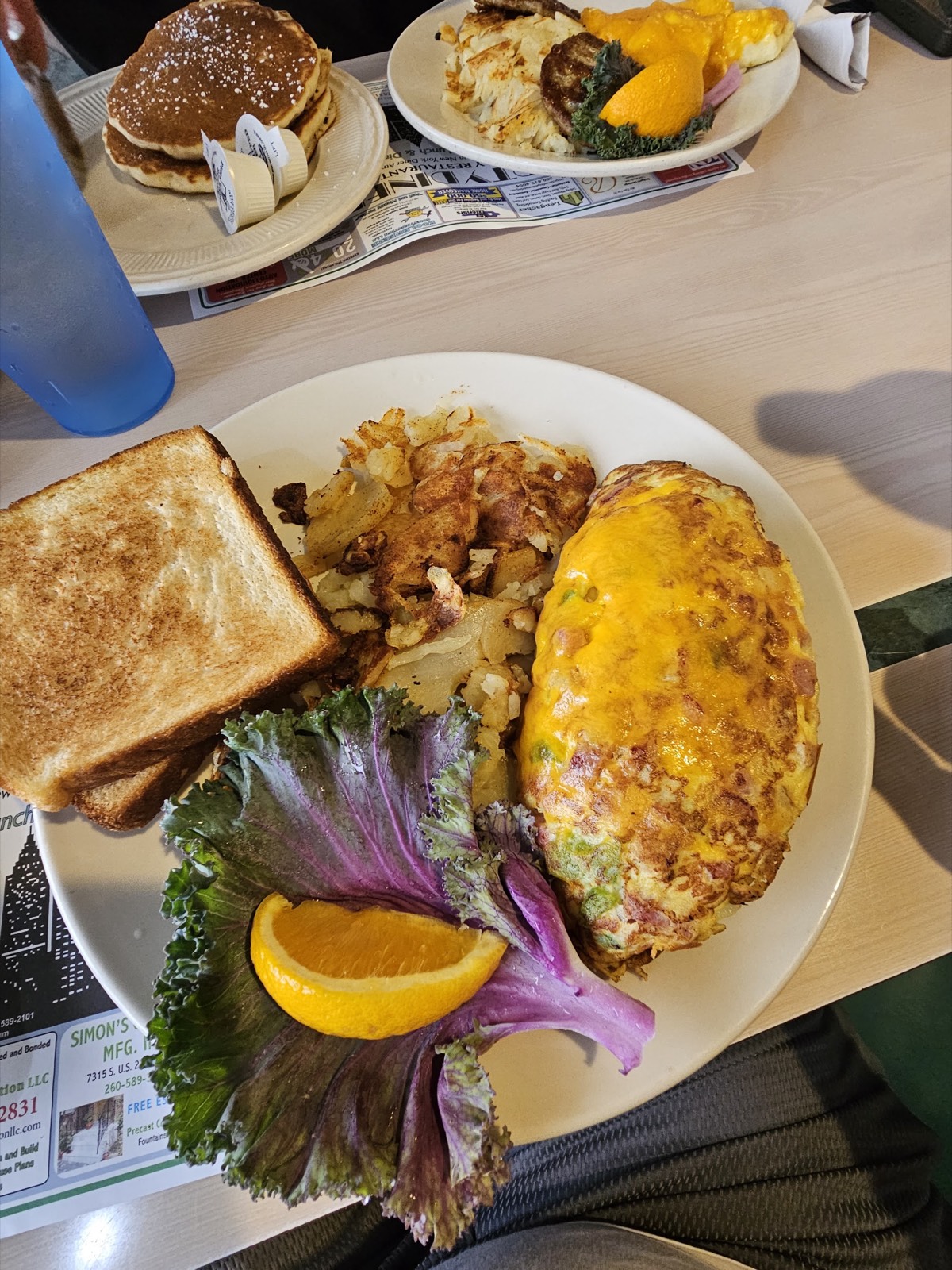 Omelette with hash browns, toast and orange garnish