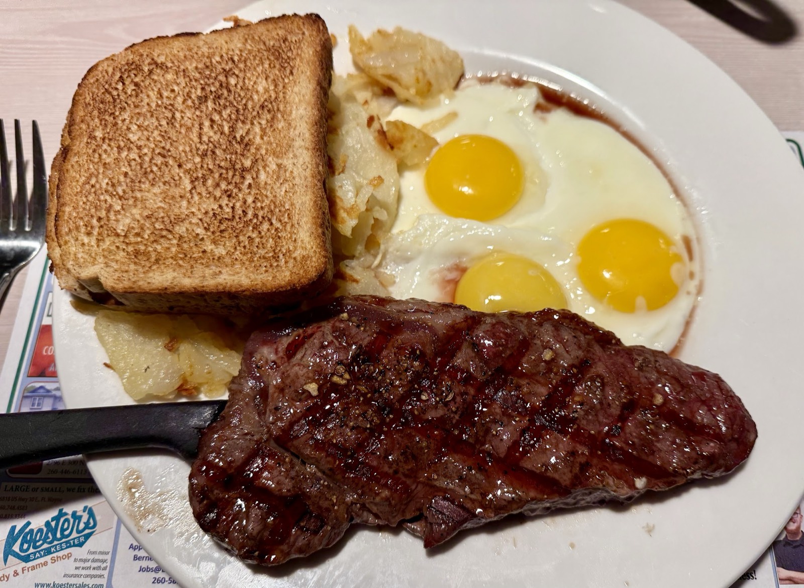 Steak and eggs with toast and hash browns