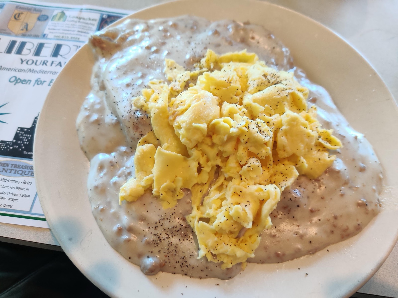 Biscuits and gravy topped with scrambled eggs